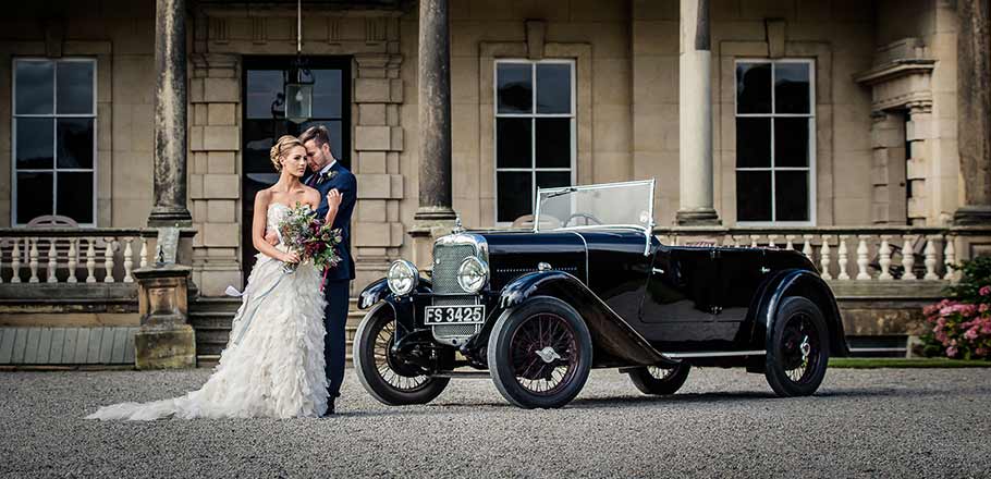 bride and groom with wedding car at Birdsall Estate