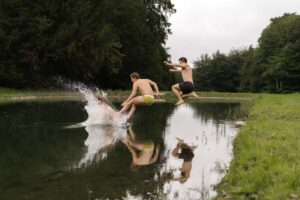 Men jump into a lake with a big splash